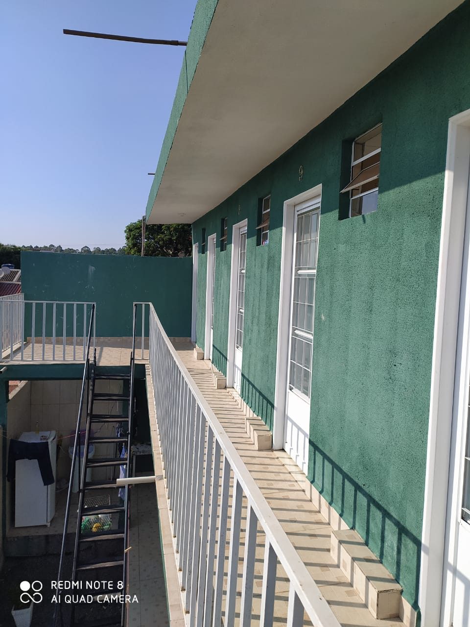 Fachada verde com acesso aos quartos do pavimento superior