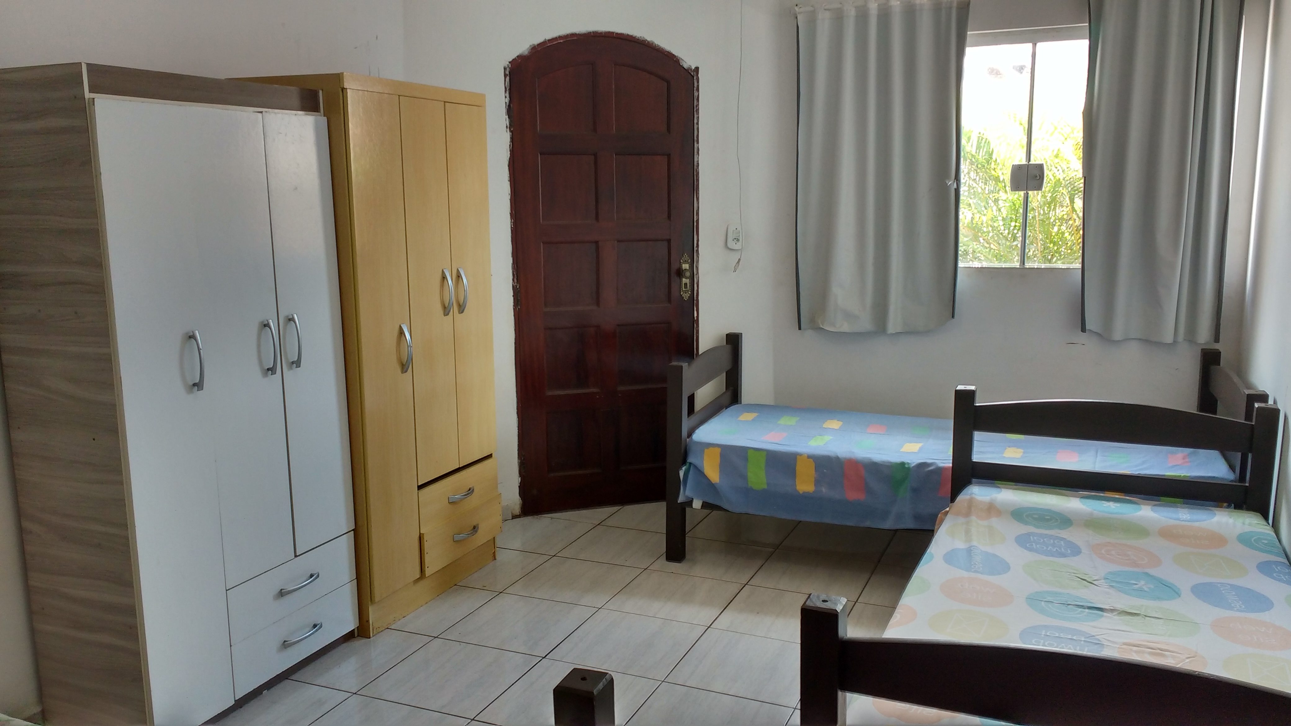 Quarto duplo com duas camas e guarda-roupas